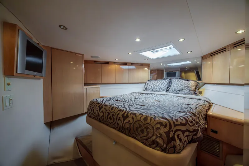 Wet Hooker Yacht Photos Pics Luxurious bedroom interior of 2003 Hatteras 60 Convertible yacht with elegant bedding and wood cabinetry.