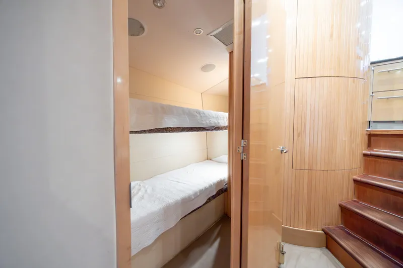 Wet Hooker Yacht Photos Pics Interior of 2003 Hatteras 60 Convertible yacht with bunk beds and wooden stairs.