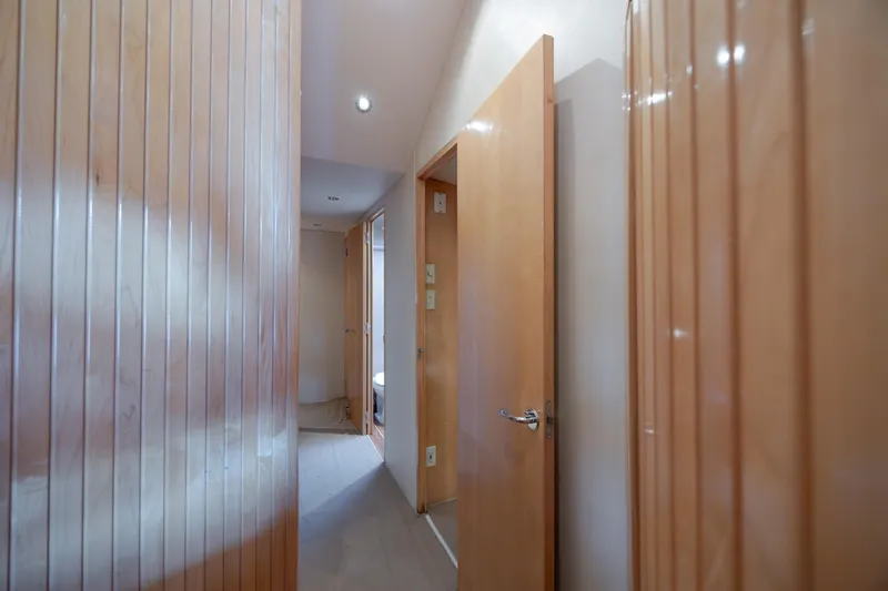 Wet Hooker Yacht Photos Pics Interior hallway of 2003 Hatteras 60 Convertible yacht with wooden paneling and open doors.