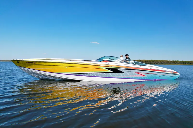  Yacht Photos Pics 2006 Formula 382 FASTech speedboat with vibrant graphics cruising on a calm lake.