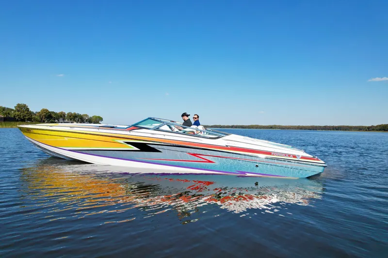  Yacht Photos Pics 2006 Formula 382 FASTech speedboat cruising on a calm lake under a clear blue sky.