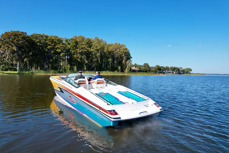  Yacht Photos Pics 2006 Formula 382 FASTech boat cruising on a serene lake with lush green shoreline.