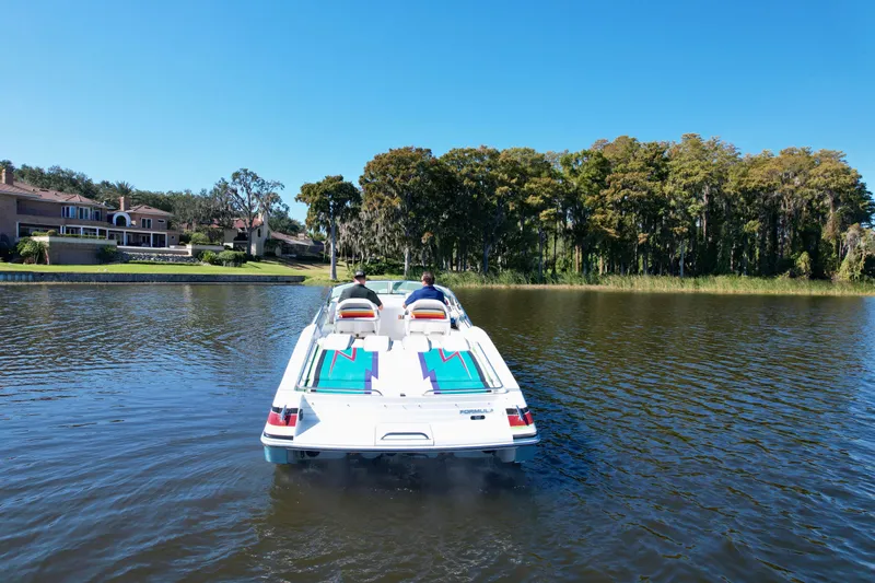  Yacht Photos Pics 2006 Formula 382 FASTech boat cruising on a serene lake with scenic background.