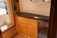 Interior of a 2012 Fjord 36' Open boat with wooden cabinetry and control panel.