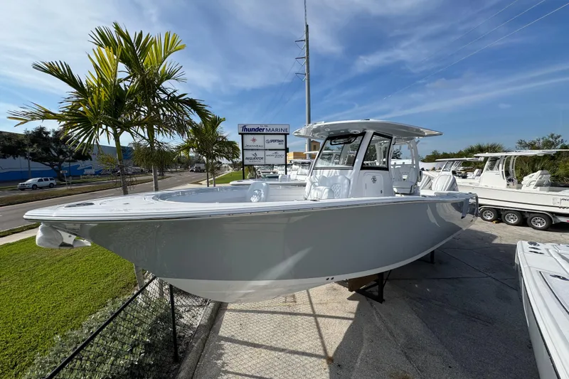  Yacht Photos Pics 2026 Sportsman Open 302 Center Console boat displayed outdoors near palm trees.