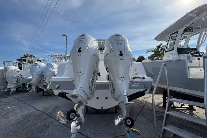  Yacht Photos Pics 2026 Sportsman Open 302 Center Console with dual outboard engines, docked under clear skies.