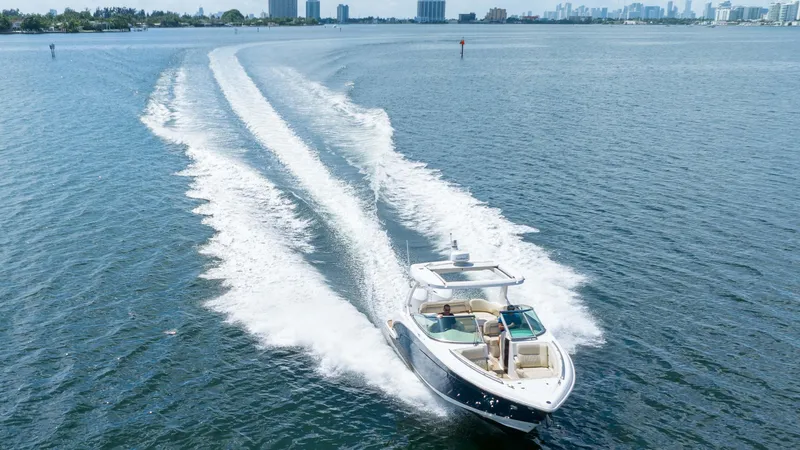 Poly Yacht Photos Pics 2019 Regal 33 OBX boat cruising on open water, leaving a wake behind.