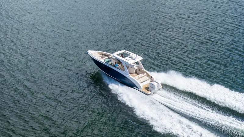 Poly Yacht Photos Pics 2019 Regal 33 OBX boat cruising on open water, creating a wake.