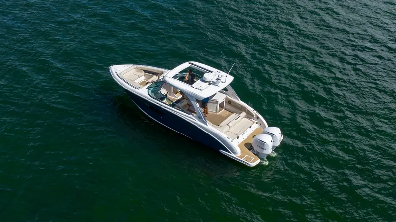 Poly Yacht Photos Pics 2019 Regal 33 OBX boat cruising on open water, aerial view.