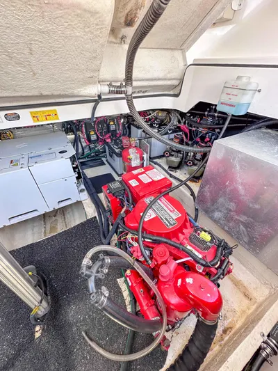Poly Yacht Photos Pics Engine compartment of a 2019 Regal 33 OBX boat, showcasing red engine and wiring.