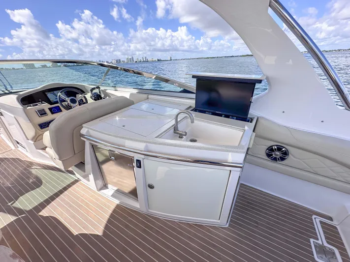 Poly Yacht Photos Pics 2019 Regal 33 OBX boat interior with helm, sink, and seating on a sunny day.