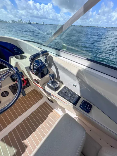 Poly Yacht Photos Pics 2019 Regal 33 OBX boat cockpit with controls, steering wheel, and ocean view.