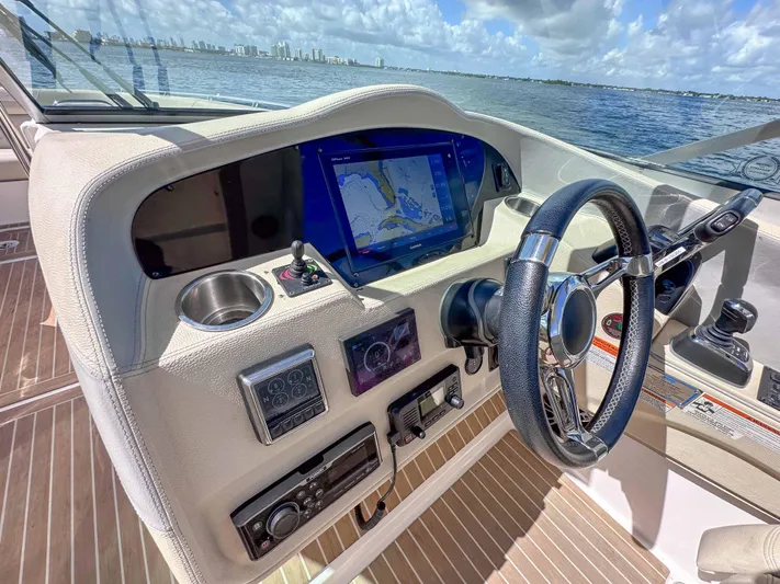 Poly Yacht Photos Pics 2019 Regal 33 OBX boat dashboard with navigation screen, steering wheel, and controls.