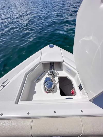 Poly Yacht Photos Pics 2019 Regal 33 OBX boat anchor compartment with open hatch on calm water.