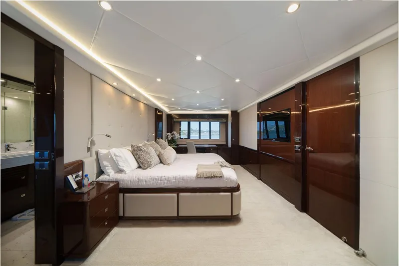 Current Sea Yacht Photos Pics Luxurious bedroom interior on a 2011 Princess 95 yacht, featuring elegant wood finishes and modern design.