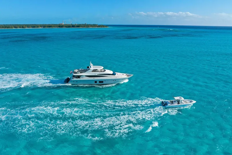 Current Sea Yacht Photos Pics Luxurious 2011 Princess 95 yacht cruising in clear turquoise waters near a tropical island.