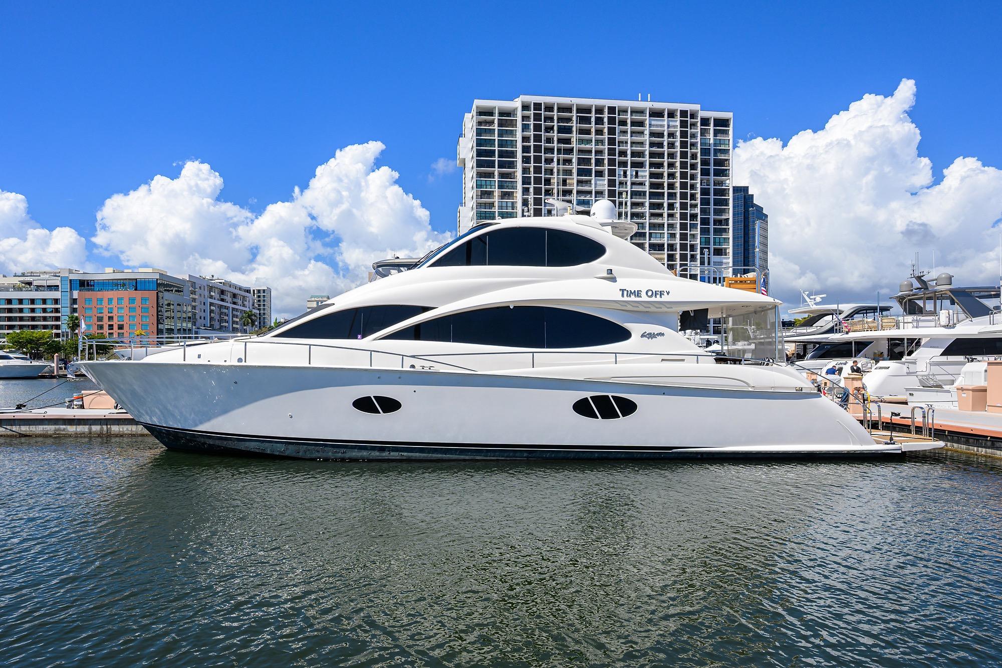 2005 Lazzara 68 Enclosed Bridge yacht docked in a marina, cityscape background.