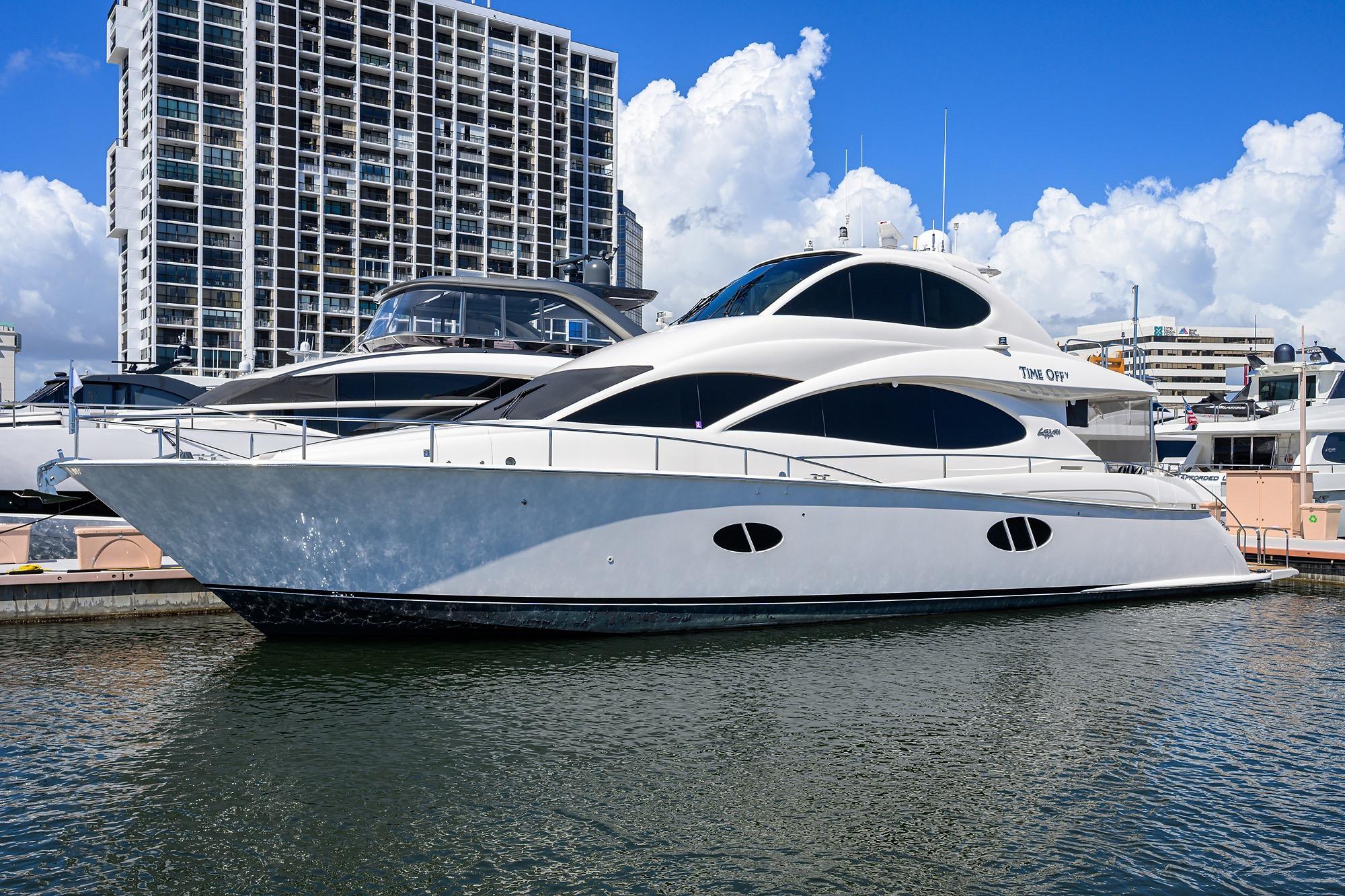 Luxury 2005 Lazzara 68 Enclosed Bridge yacht docked in marina, modern design.