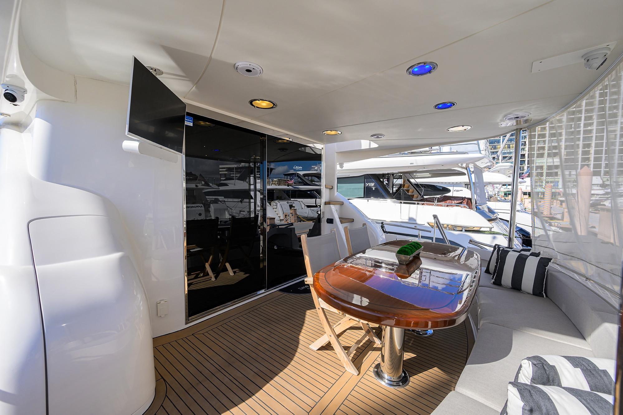 Luxurious 2005 Lazzara 68 Enclosed Bridge yacht with elegant outdoor seating and dining area.