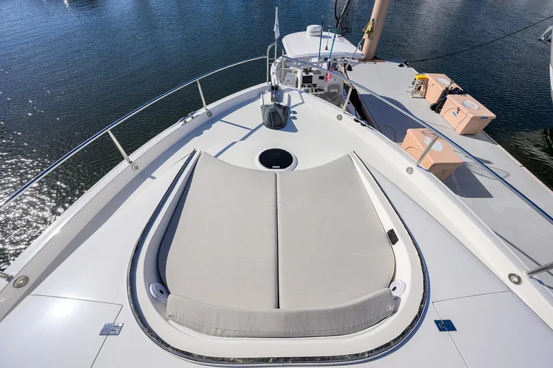 Time Off V Yacht Photos Pics 2005 Lazzara 68 Enclosed Bridge yacht deck with sunbed, overlooking calm water.