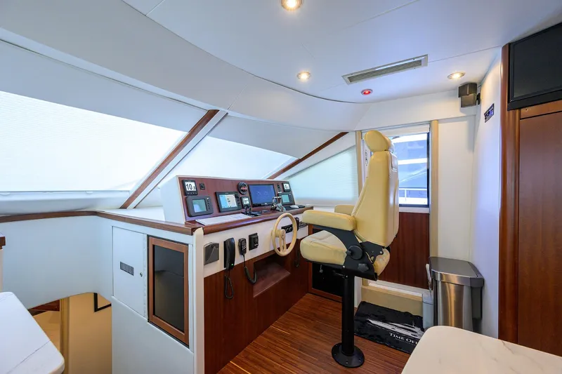 Time Off V Yacht Photos Pics Interior helm of 2005 Lazzara 68 Enclosed Bridge yacht with modern controls and captain's chair.