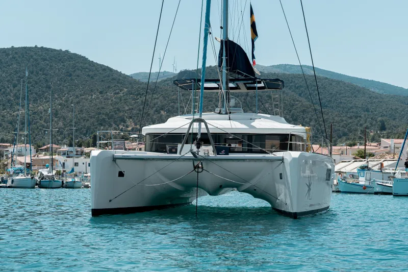  Yacht Photos Pics 2018 Lagoon 52 F catamaran docked in a scenic marina with hills in the background.