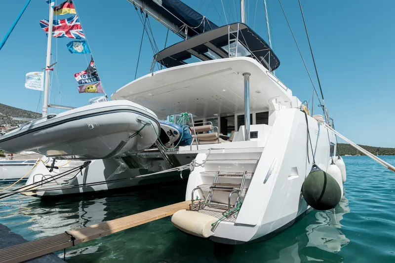  Yacht Photos Pics 2018 Lagoon 52 F catamaran docked with flags and inflatable boat.