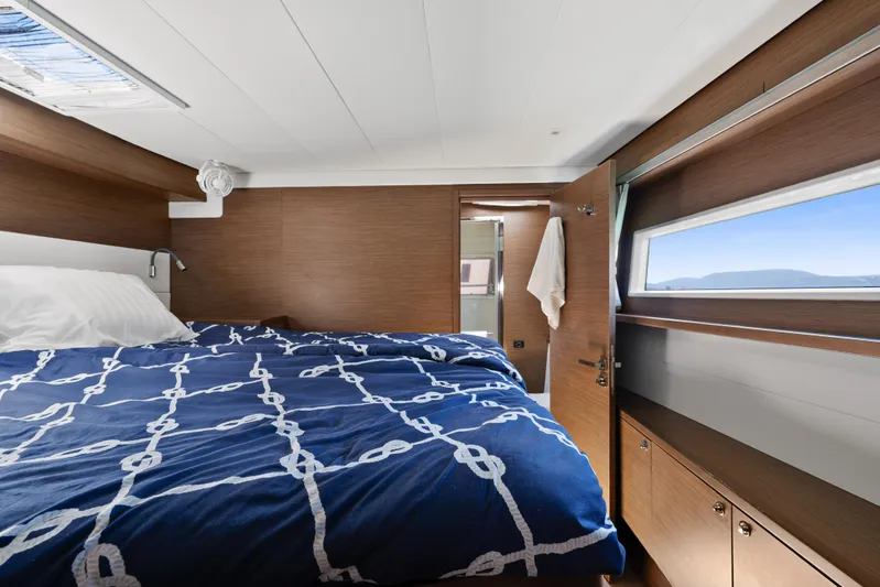  Yacht Photos Pics Luxurious cabin interior of 2018 Lagoon 52 F yacht with nautical bedding and scenic window view.