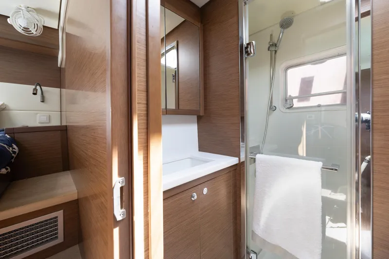  Yacht Photos Pics Luxurious bathroom interior of 2018 Lagoon 52 F yacht with modern shower and wooden finishes.