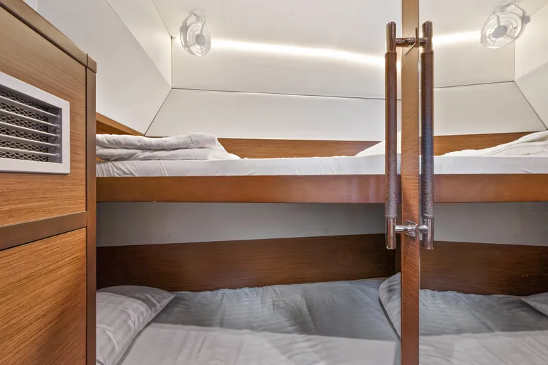  Yacht Photos Pics Bunk beds in 2018 Lagoon 52 F yacht cabin, featuring modern wood design and cozy bedding.