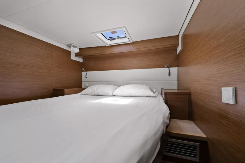  Yacht Photos Pics Luxurious cabin interior of 2018 Lagoon 52 F yacht with cozy bed and wooden finish.