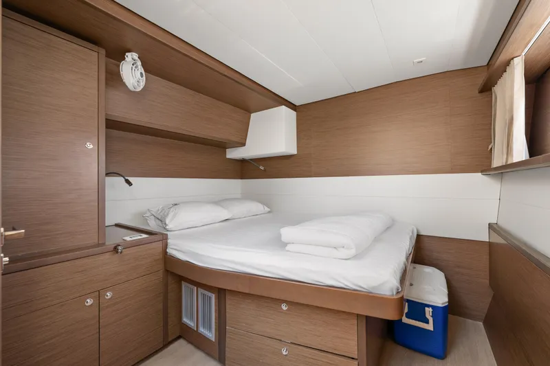  Yacht Photos Pics Luxurious cabin interior of 2018 Lagoon 52 F yacht with cozy bed and wooden furnishings.