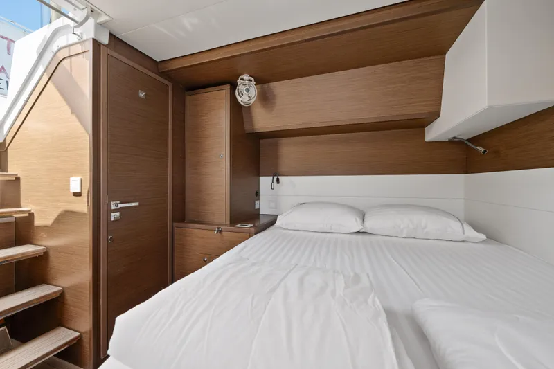  Yacht Photos Pics Luxurious cabin interior of 2018 Lagoon 52 F yacht with wooden accents and cozy bedding.