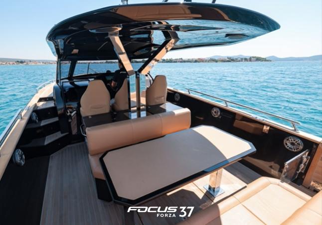 Luxurious 2025 Focus Forza 37 yacht interior with seating and table on open water.