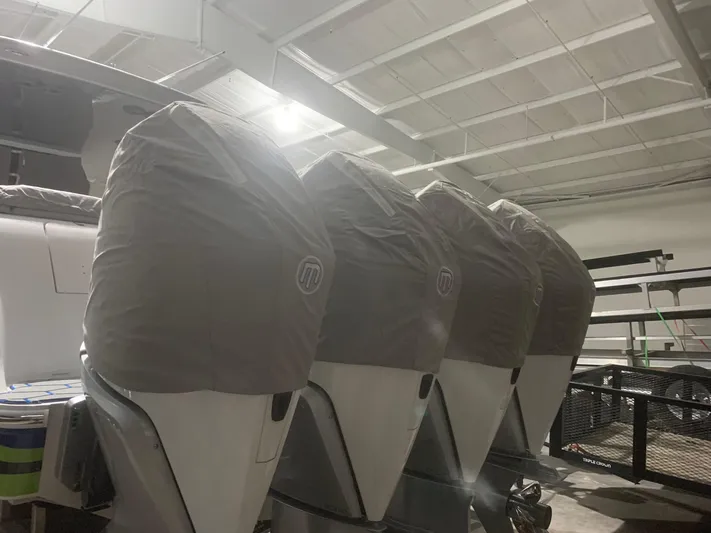  Yacht Photos Pics Four covered outboard motors on a 2020 Mystic Powerboats M4200 in a storage facility.