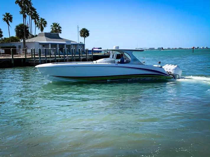  Yacht Photos Pics 2020 Mystic Powerboats M4200 cruising on a sunny day near a dock.