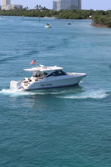 Knot Sorry Yacht Photos Pics 2021 Tiara Yachts 38LX cruising on clear blue water with American flag.
