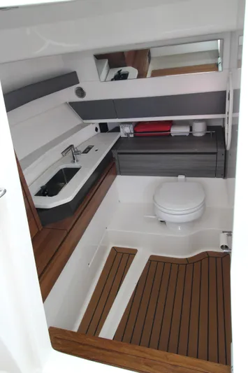 Knot Sorry Yacht Photos Pics 2021 Tiara Yachts 38LX bathroom with modern sink, toilet, and wooden accents.