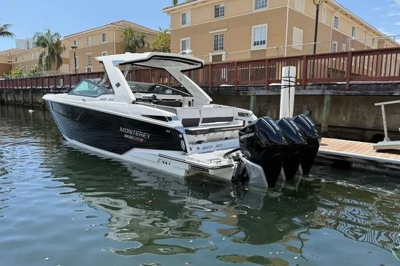  Yacht Photos Pics 2023 Monterey 385 Super Sport boat docked in a marina, featuring triple Mercury engines.