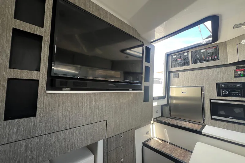  Yacht Photos Pics 2023 Monterey 385 Super Sport interior with modern entertainment system and sleek cabinetry.