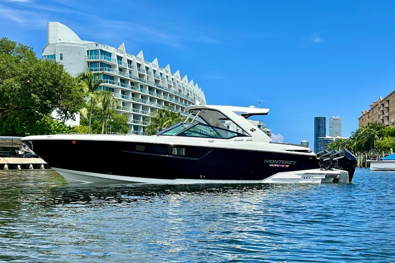  Yacht Photos Pics 2023 Monterey 385 Super Sport boat on water, modern architecture in background.