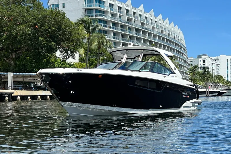  Yacht Photos Pics 2023 Monterey 385 Super Sport boat on water near modern buildings and trees.