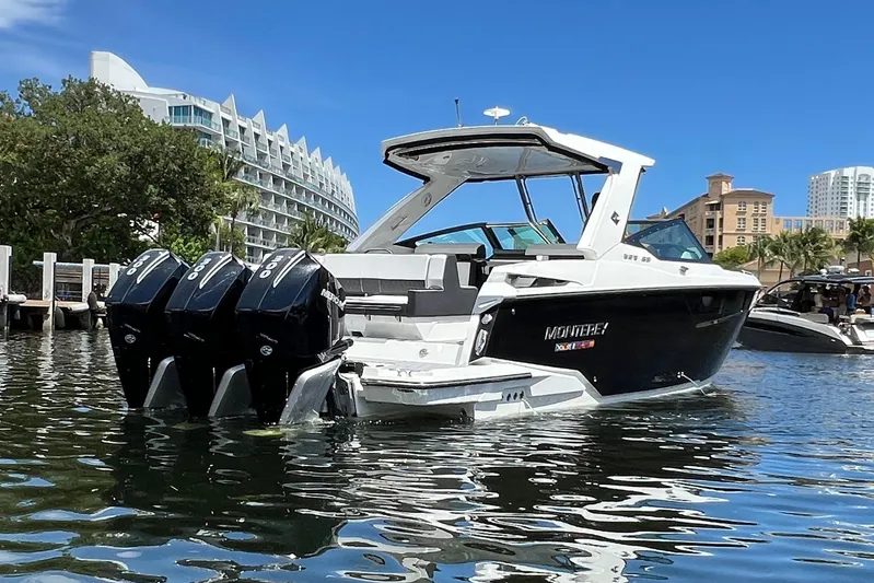 Yacht Photos Pics 2023 Monterey 385 Super Sport boat with triple engines on a sunny waterfront.