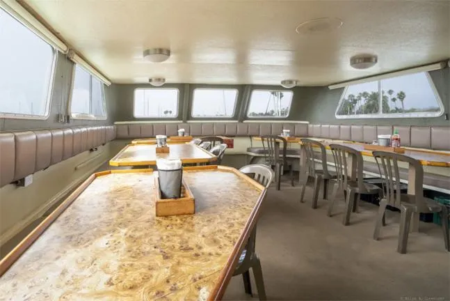 Truth Yacht Photos Pics Interior of 1974 Custom Expedition Liveaboard with dining tables and panoramic windows.