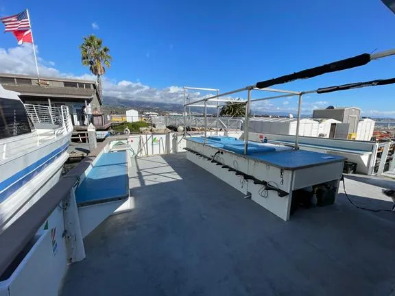 Truth Yacht Photos Pics Expedition Liveaboard deck, 1974 model, with seating and equipment, under clear blue sky.