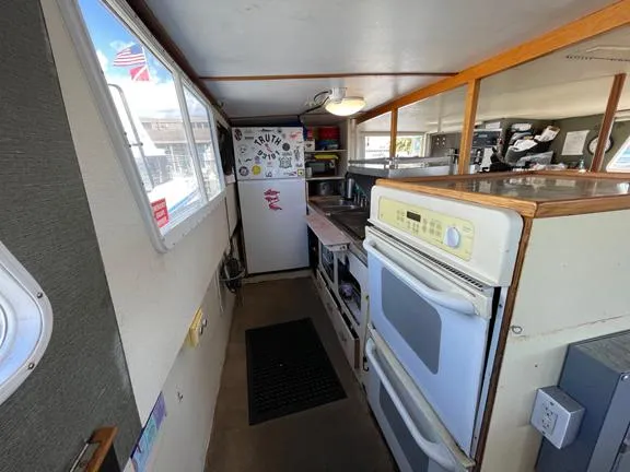 Truth Yacht Photos Pics 1974 Custom Expedition Liveaboard kitchen with oven, fridge, and window view.