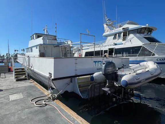 Truth Yacht Photos Pics 1974 Custom Expedition Liveaboard boat docked beside Condor Express under clear blue sky.