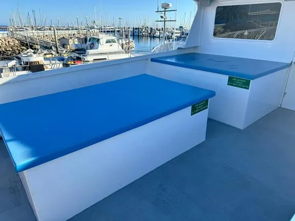 Truth Yacht Photos Pics 1974 Custom Expedition Liveaboard boat with blue seating, docked at a marina.