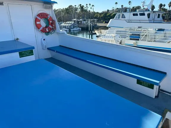 Truth Yacht Photos Pics 1974 Custom Expedition Liveaboard boat deck with blue seating and life preserver.