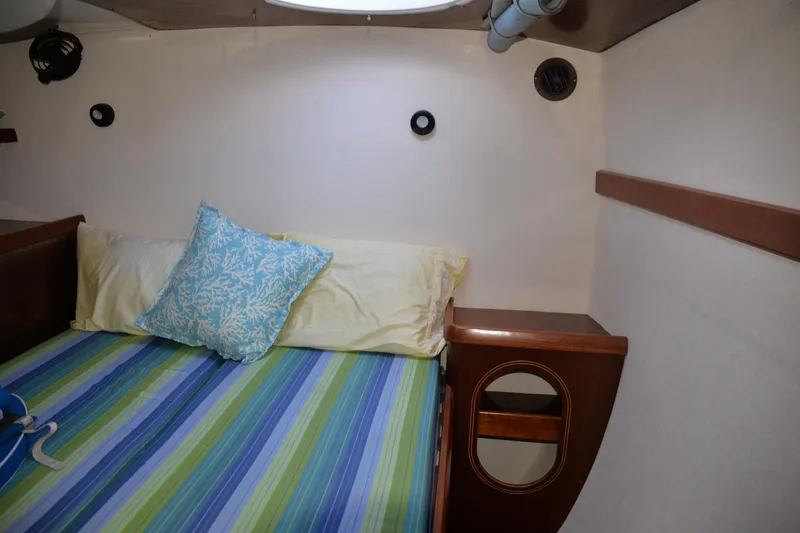 Dreamweaver Yacht Photos Pics Cozy cabin interior of 2004 Fountaine Pajot Belize 43 with striped bedding and wooden accents.